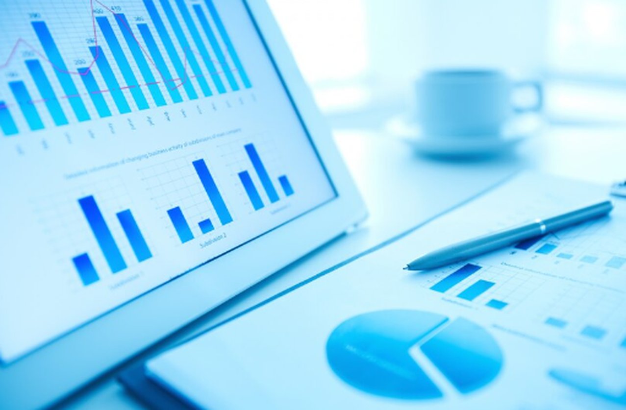 Gráficos de desempenho financeiro exibidos em tablet e relatórios sobre a mesa, representando a análise de dados estatísticos e o monitoramento de investimentos em fundos quantitativos no ambiente corporativo.